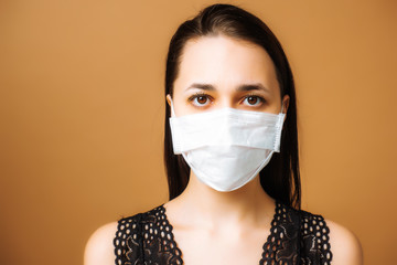 Close-up portrait of a woman in a medical mask. Coronavirus infection. Pandemic. Self isolation.