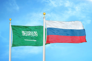 Saudi Arabia and Russia two flags on flagpoles and blue cloudy sky
