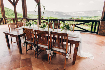 Fototapeta na wymiar Decorated wedding table for the newlyweds and guests with mountain views. Wedding decor and Floristics.
