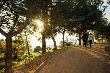 Old couple walking through a park at sunset