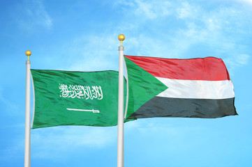 Saudi Arabia and Sudan two flags on flagpoles and blue cloudy sky