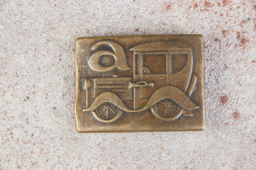 Old brass belt buckle with a car