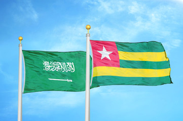 Saudi Arabia and Togo two flags on flagpoles and blue cloudy sky
