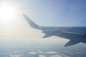 wing of the plane against the blue sky with clouds. view from eluminator to the wing of the aircraft against the sky.flight, vacation, tourism.View through the window of an airplane.traveling by a