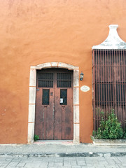 Alte Holztür vor ockerfarbenem Haus in Valladolid, Mexiko