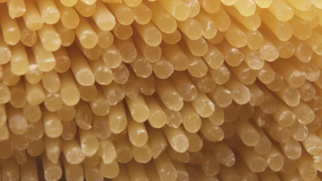 Close-up of a bunch of uncooked dried spaghetti, noodles. Italian pasta background