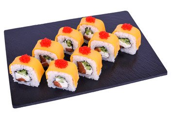 Traditional fresh japanese sushi rolls on black stone Syake Cheese on a white background. Roll ingredients: salmon, philadelphia cheese, cheddar cheese, cucumber, tobik caviar, nori, rice.
