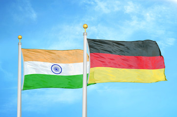 India and Germany two flags on flagpoles and blue cloudy sky