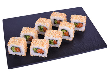 Traditional fresh japanese sushi rolls on black stone California shake sesame on a white background. Roll ingredients: salmon, cucumber, mayonnaise, nori, rice, sesame.