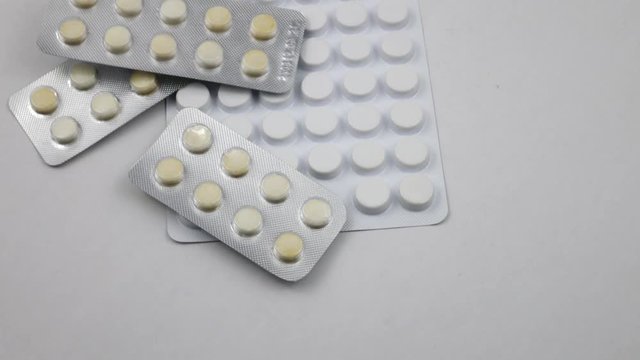 Pills in blister packs are laid out on a white background