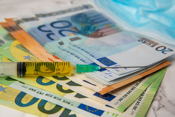 cost of coronavirus breakdown in europe Euro banknotes and vaccine