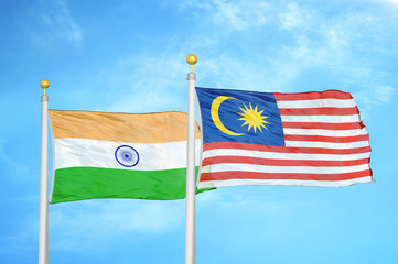 India and Malaysia two flags on flagpoles and blue cloudy sky