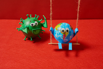 Green virus pushing a toy earth on a swing