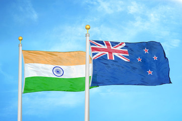 India and New Zealand two flags on flagpoles and blue cloudy sky