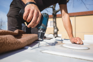 A hole gets drilled into the roof of a van