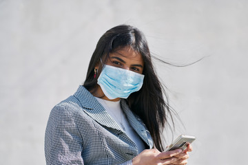 Girl with a mask to avoid contagion walking down the street. Coronavirus concept