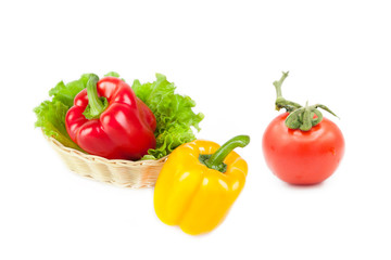 Ripe fresh organic vegetables in a basket and tomato in dew drops isolated on a white background