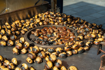 Roasted chestnuts for sale on street. Delicious and healthy snacks. Cooked fast food.