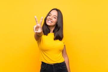 Young brunette girl over isolated background smiling and showing victory sign