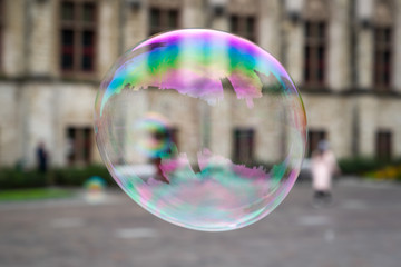 Big soap bubble flies through air in historical city Ghent, Belgium .