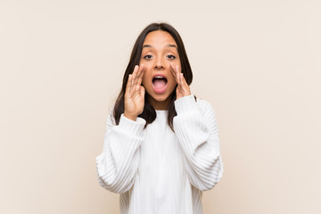 Young brunette woman with white sweater over isolated background shouting with mouth wide open