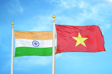 India and Vietnam two flags on flagpoles and blue cloudy sky