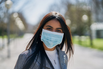 Girl with a mask to avoid contagion walking down the street. Coronavirus concept