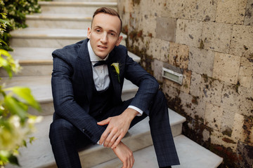 Young man in blue suit in the garden 