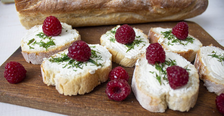 Sandwiches on a wooden board. On a white background. Raspberries. Copyspace