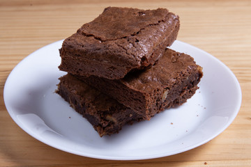 Homemade dark chocolate brownies on white table.