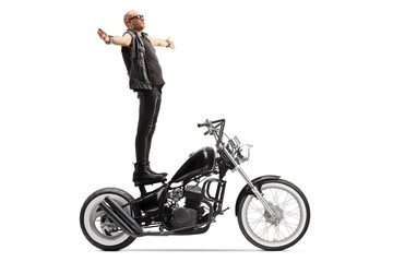 Fototapeta na wymiar Bald punk daredevil man standing on a chopper motorbike