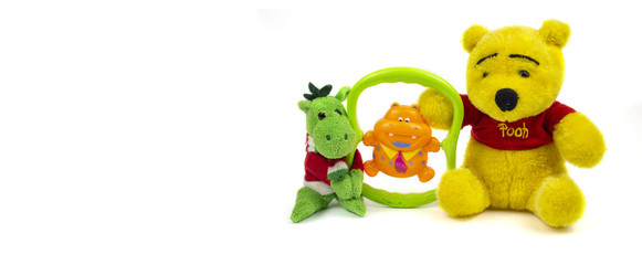 Toys isolated on white space. Bear, baby dragon and rattle. Kids toys. Banner. copyspace