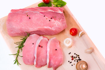 Closeup raw meat with mushrooms and tomato on a wooden plate 