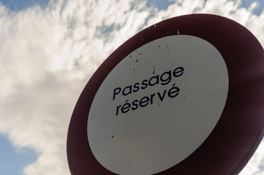 Road sign saying "Passage réservé" (tr: No Entry) on a private road