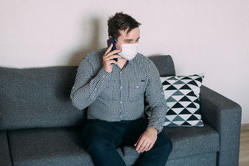 Man wearing mask using smartphone working from home office