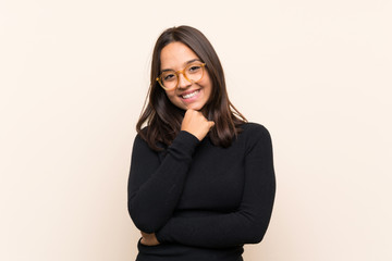 Young brunette woman with white sweater over isolated background with glasses and smiling