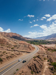 Andes Mountains, Cerro de los Siete Colores, Purmamarca Jujuy, Argentina colourful rock formation village and blue sky
