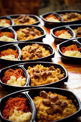 hot dish of meat and vegetables,with a side dish in a disposable container,for delivery of food at home
