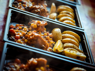 chicken with vegetables and potato wedges,in a disposable container,for delivery of food at home