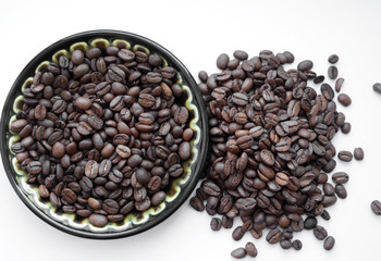 Natural coffee beans on a plate, nk white background. View from above.