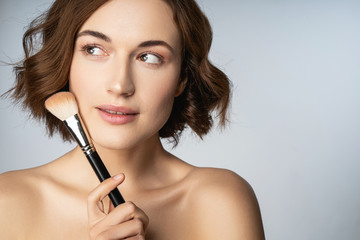 Fototapeta premium Portrait of pleased girl that thinking about makeup