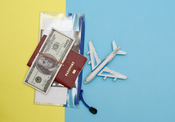 n a yellow-blue background model airplane passport voucher in a plastic transparent bag and dallars.