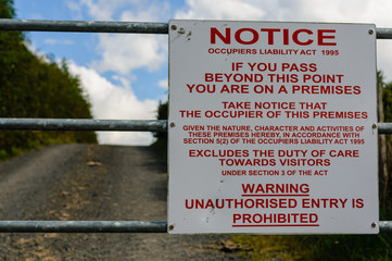 Occupiers Liability Act 1995 notice sign on the gate of a farm warning that unauthorised entry is prohibited.