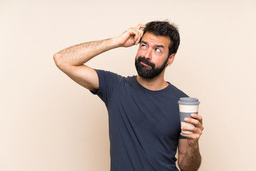 Man with beard holding a coffee having doubts and with confuse face expression