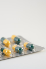                               Antibiotics pills yellow and blue colour capsules. Copy space.