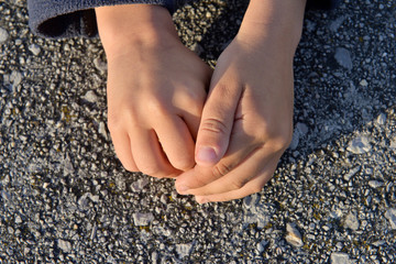 Hands of a child hiding something