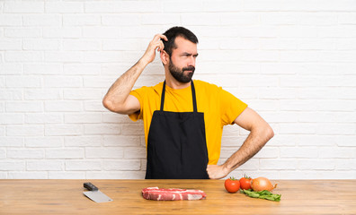 Chef holding in a cuisine having doubts while scratching head