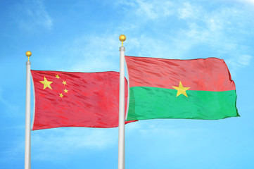 China and Burkina Faso two flags on flagpoles and blue cloudy sky