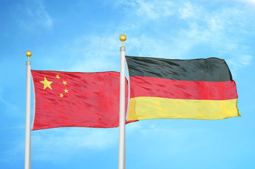 China and Germany two flags on flagpoles and blue cloudy sky