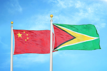 China and Guyana two flags on flagpoles and blue cloudy sky
